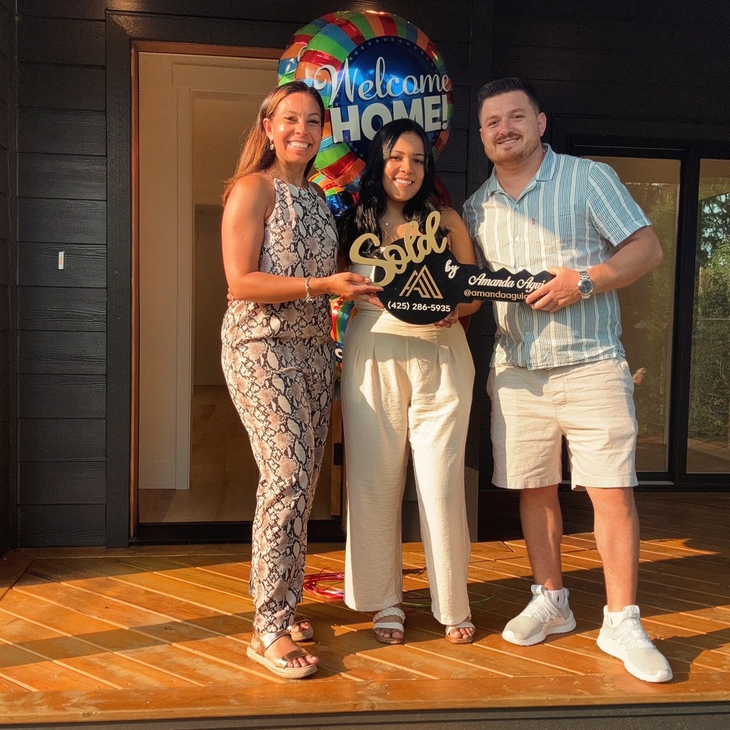 Amanda Aguiar with clients celebrating a closing, Sold key and closing gift